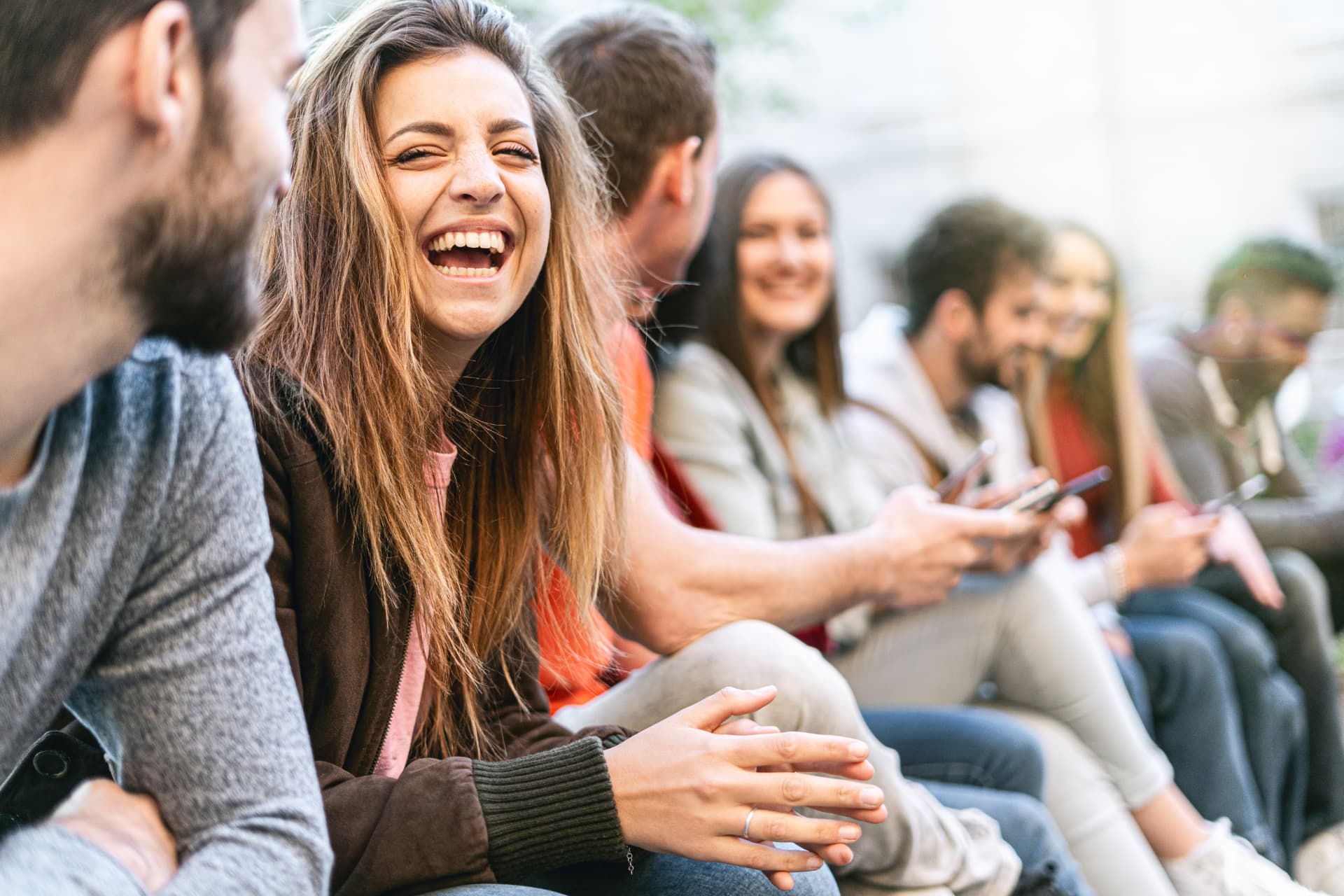 A group of young people laughing together outdoors