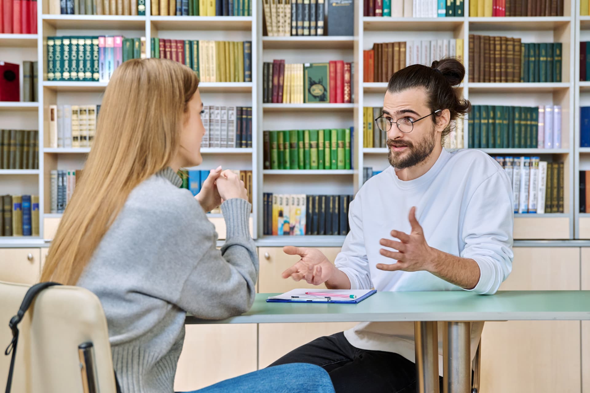 Two learners discussing ideas in a library